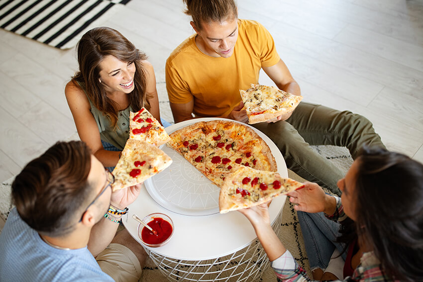 cheerful-group-of-friends-having-fun-at-home-eatin-XX7EJBK