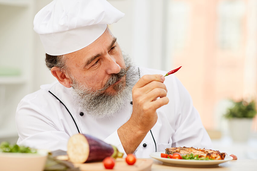senior-chef-holding-chili-pepper-EYKDMKE-3